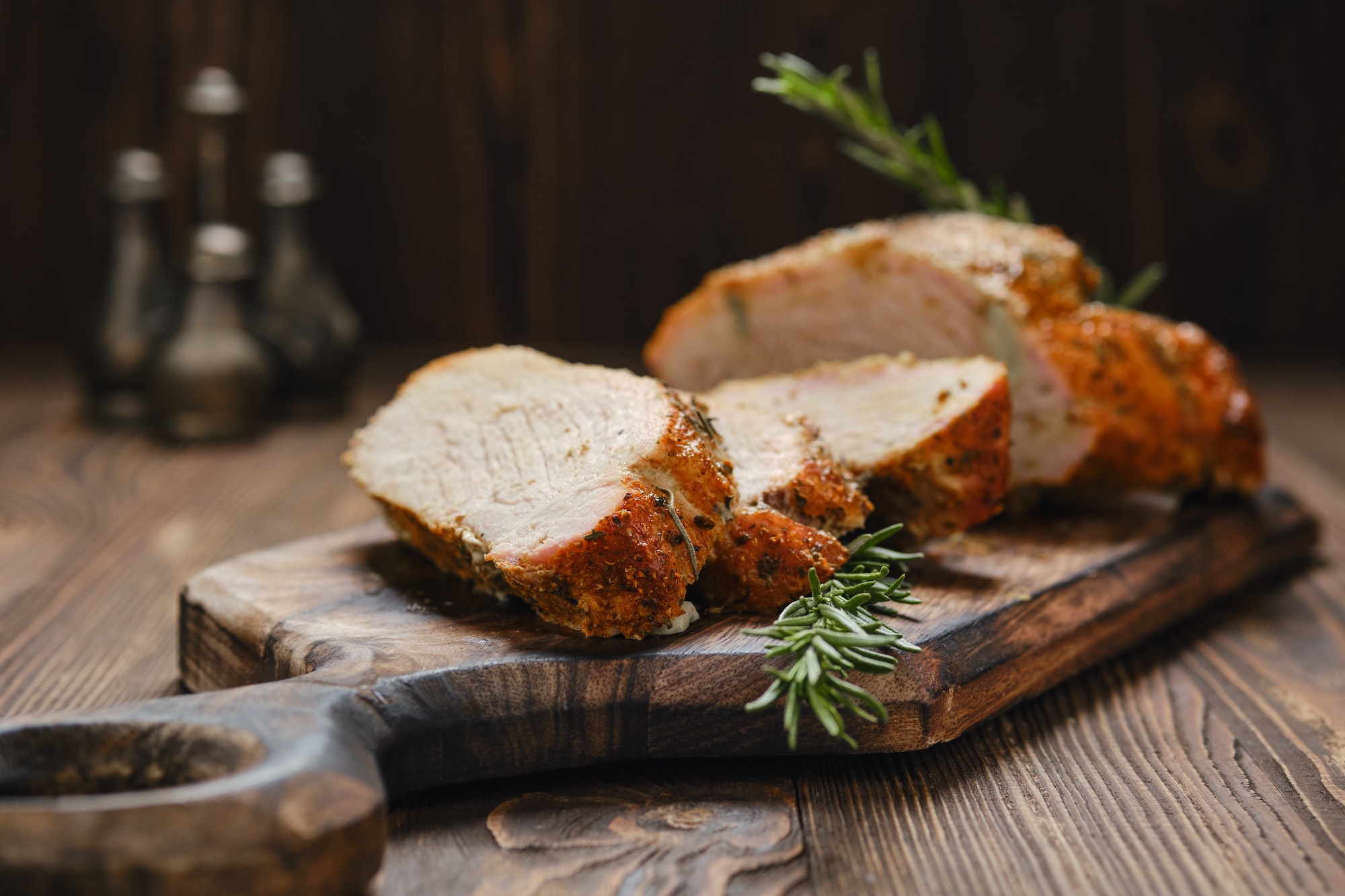 Closeup view of pork collar joint baked in oven on wooden serving board